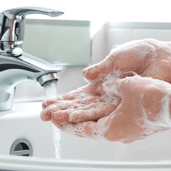 Person washing hands in sink.